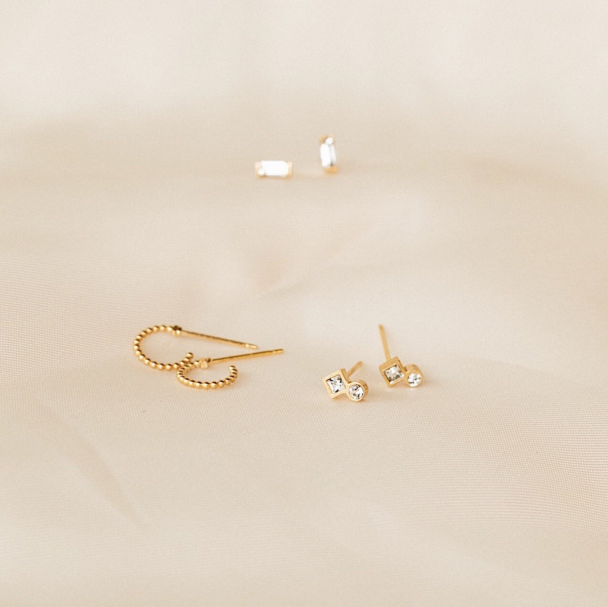 Earrings flatlay photo on satin by Katie Dean Jewelry, nickel free and made in America