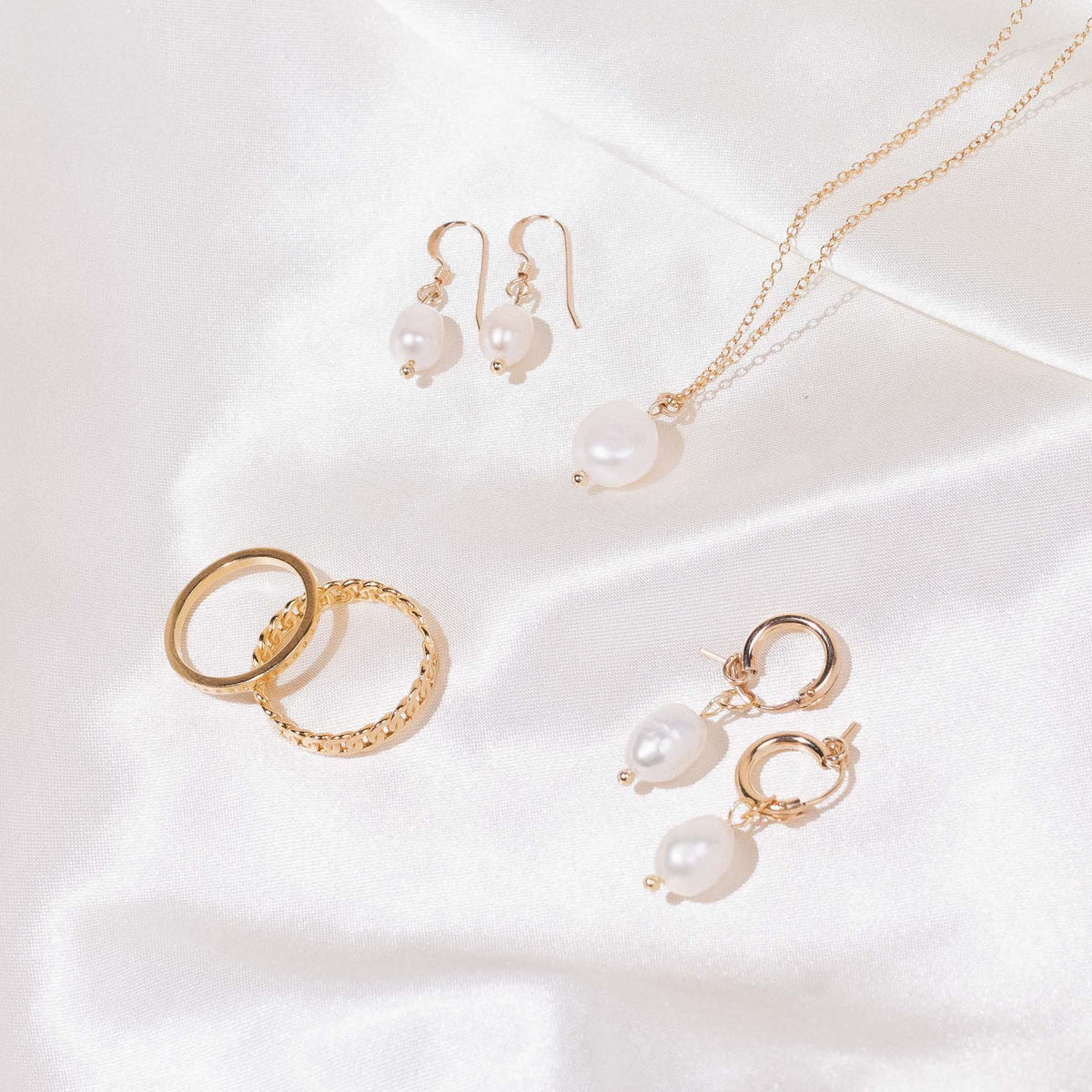 Dainty, delicate Pearl Collection flatlay photo on satin by Katie Dean Jewelry, nickel free and made in America