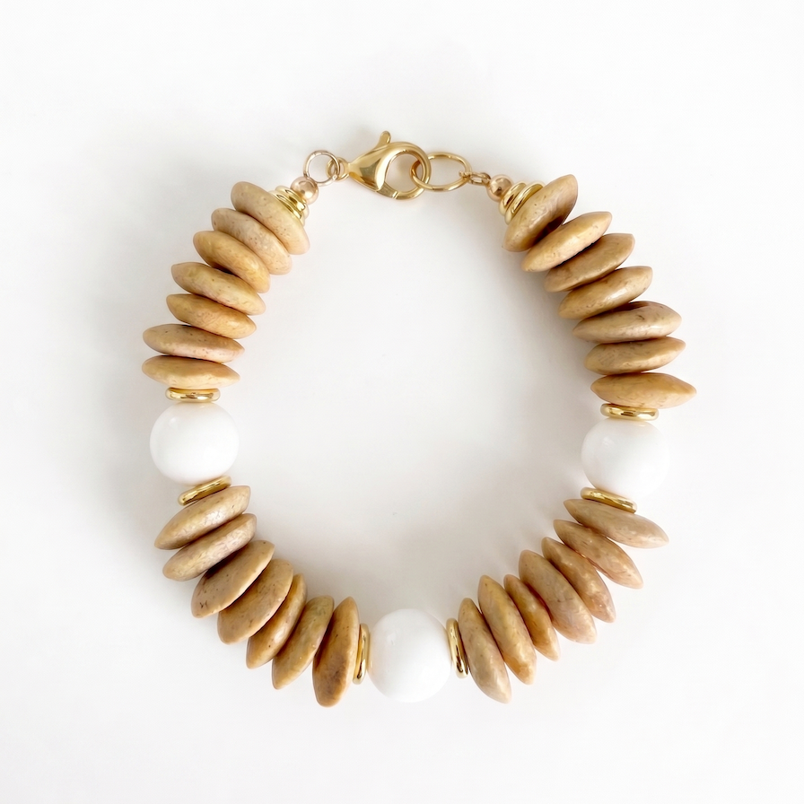 Bracelet with beige and white bead design on a white background
