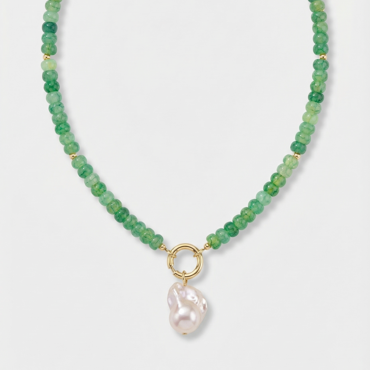 Green beaded necklace with large pearl charm on a white background.
