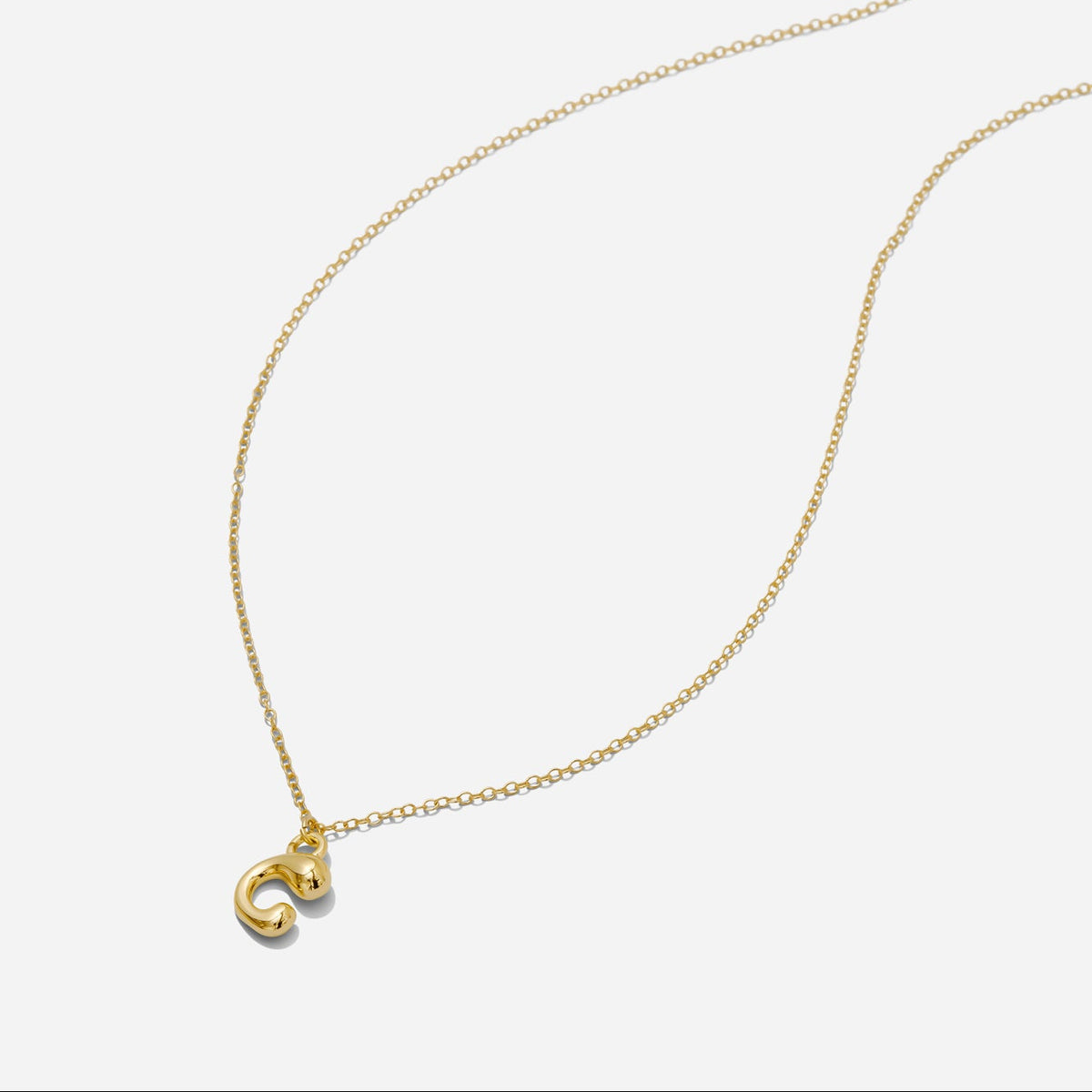 Dainty Gold puffy initial "C" pendant necklace on an 18-inch gold filled chain as seen on a white background.