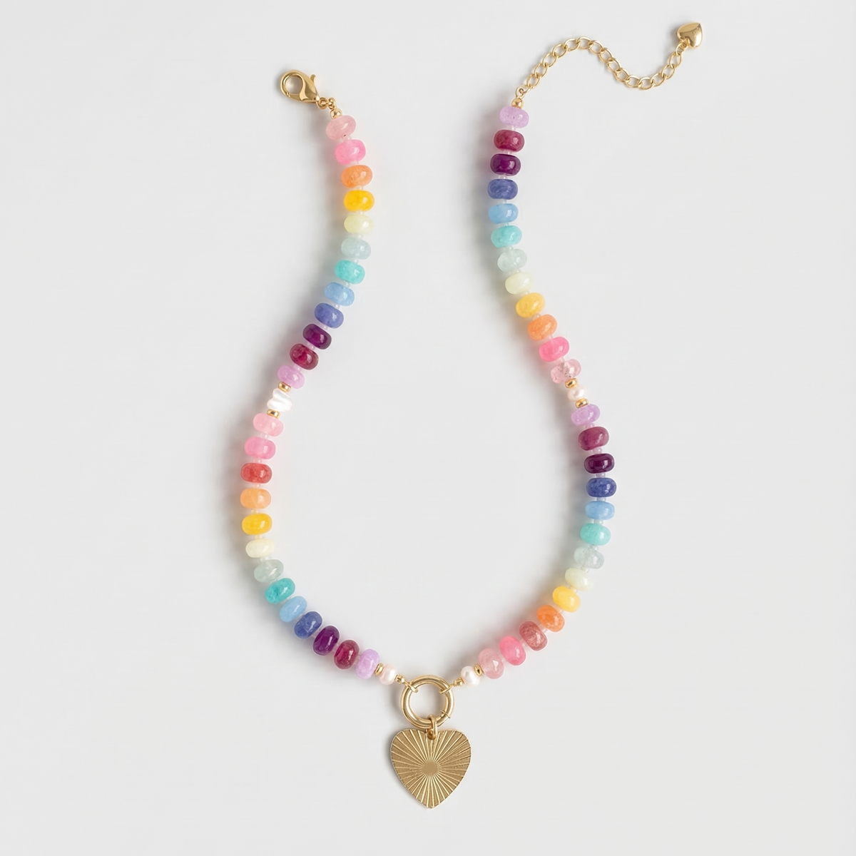 Multicolored beaded necklace with a gold heart charm on a white background