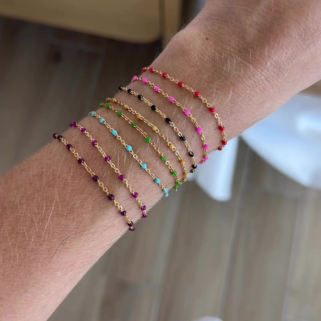Enamel Chain Bracelets, in various colors, shown on a wrist in a stack side by side. Bracelet is hand assembled by Katie Dean Jewelry in clearwater, FL.
