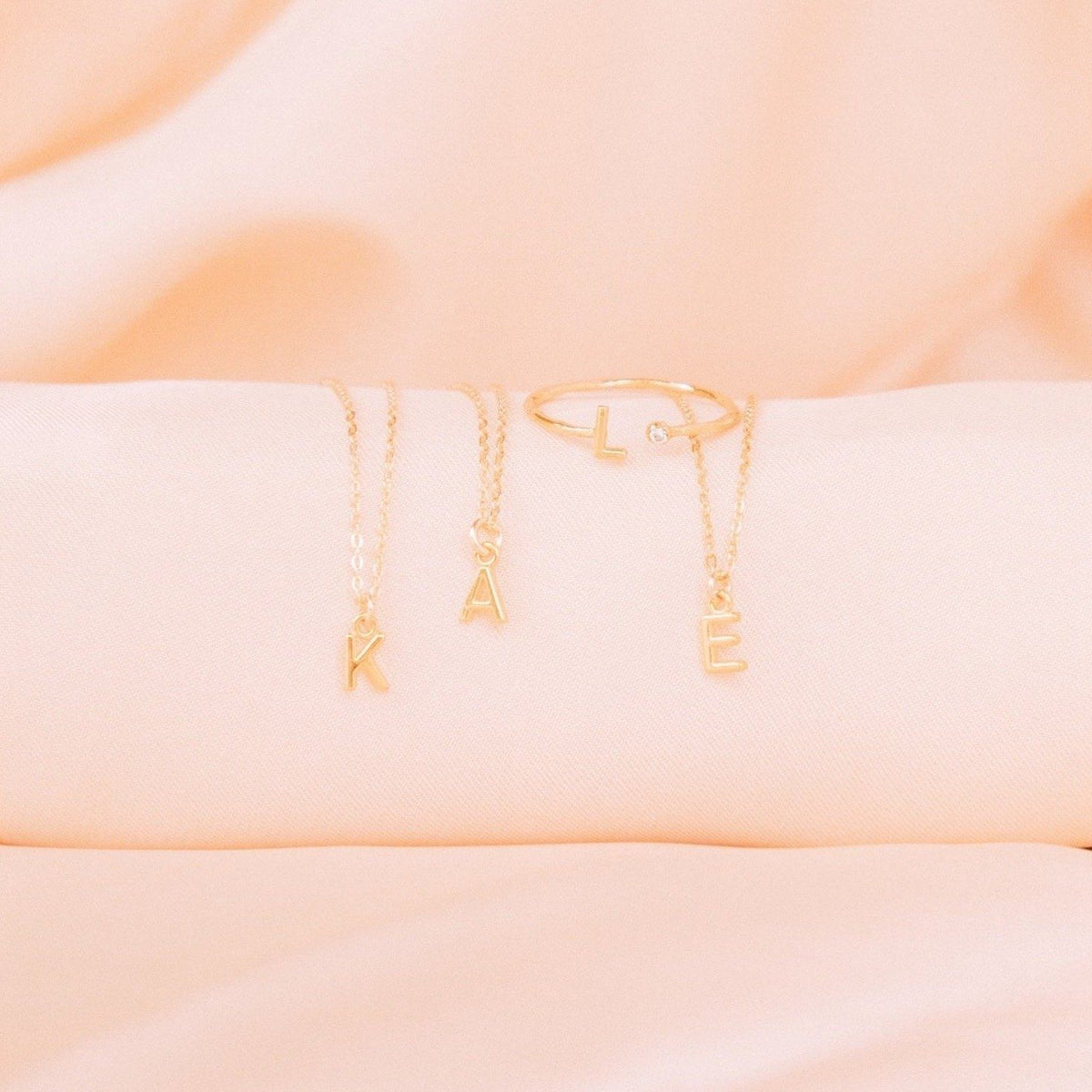 Initial Necklaces on pink satin, Initials K A E, made by Katie Dean Jewelry
